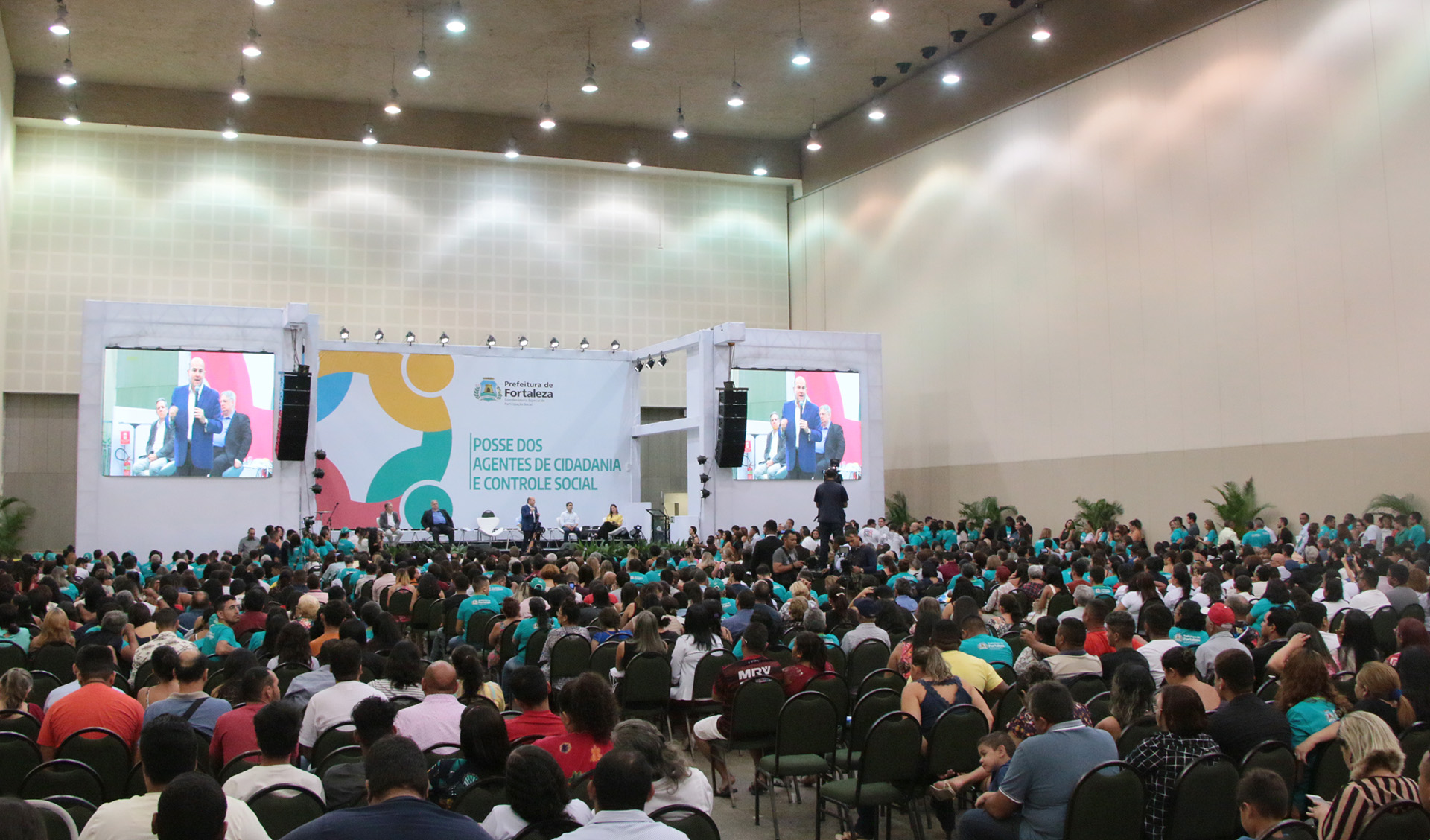 interior do auditorio do centro de eventos com centenas de pessoas na plateira